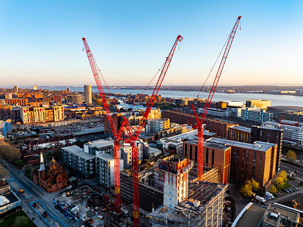 Aerial view of a construction site in liverpool, england, with cranes and buildings at sunset