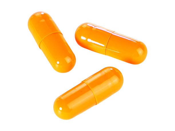 istock Bulk orange capsule pills isolated on white background. 2220496486