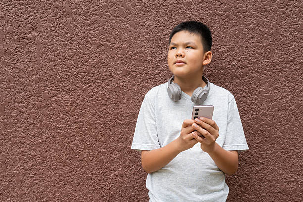 istock Teenager Boy Portrait Against Plain Wall in Natural Light 2220497609