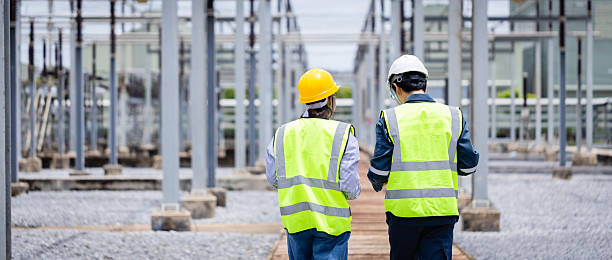 istock Engineer is working at high voltage power substation wearing safety gear while conducting inspection and check of electrical infrastructure to ensure proper operation and safety 2220497922