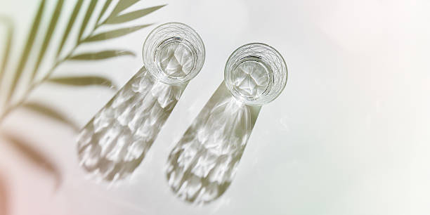istock Water Glasses with palm leaf Shadow and sunlight Reflection on white, banner, colored photo minimal style, aesthetic top view summer still life, refraction throug crystal shine cups, caustic 2220500107