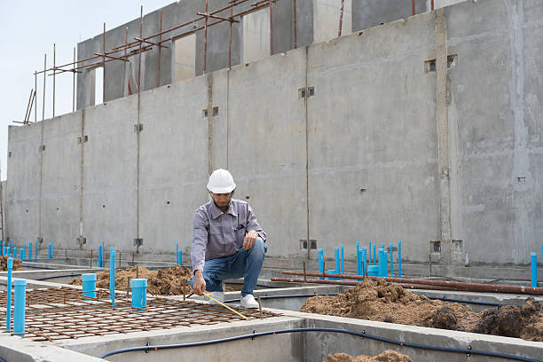 istock Construction site. Building foundation structure. Civil engineer. Network of pipes. Construction engineer supervising construction work at construction site. Plumber working in sewer pipes area 2220503146