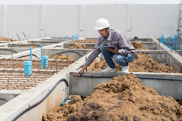 istock Construction site. Building foundation structure. Civil engineer. Network of pipes. Construction engineer supervising construction work at construction site. Plumber working in sewer pipes area 2220503147
