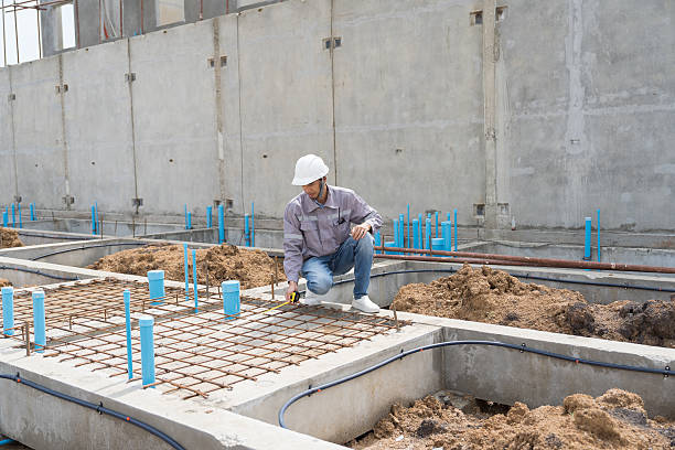 Construction site. Building foundation structure. Civil engineer. Network of pipes. Construction engineer supervising construction work at construction site. Plumber working in sewer pipes area
