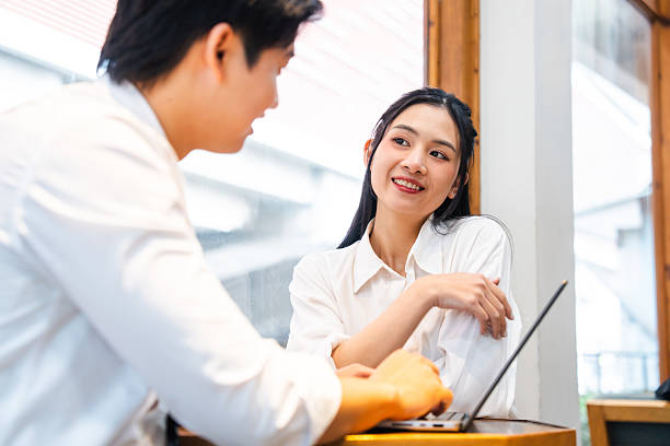 istock Two young professionals collaborate using a laptop in a bright and modern office setting 2220503783