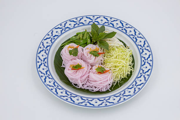 Kanom Jeen Sao Nam, Thai food, Traditional Thai rice noodles beautifully arranged with fresh vegetables and herbs on white background