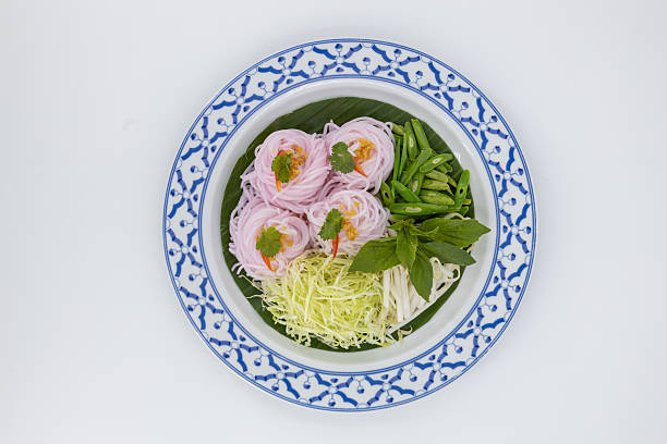 Kanom Jeen Sao Nam, Thai food, Traditional Thai rice noodles beautifully arranged with fresh vegetables and herbs on white background