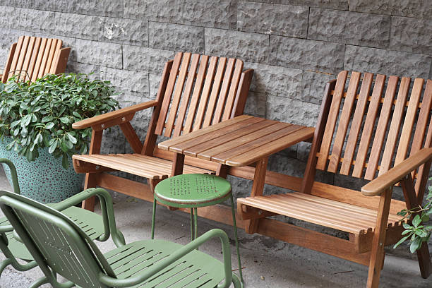 istock Wooden chairs and small table arranged near a stone wall 2220506344