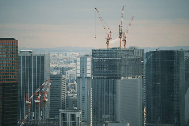 Cluster of tower cranes working above glass high-rises, illustrating urban growth, development and modern engineering.