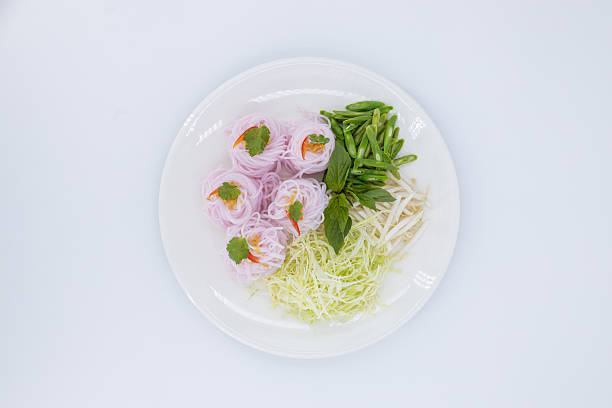 Kanom Jeen Sao Nam, Thai food, Traditional Thai rice noodles beautifully arranged with fresh vegetables and herbs on white background