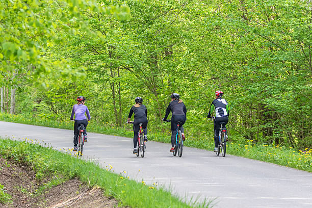 Falköping, Sweden-May, 2020: Women who exercise on bicycle at a road in a forest