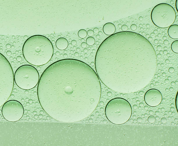 Macro microscope green bubble texture, Close-up Green bubbles and drops oil background . blue green water bubbles, close up golden oil drop for cosmetic