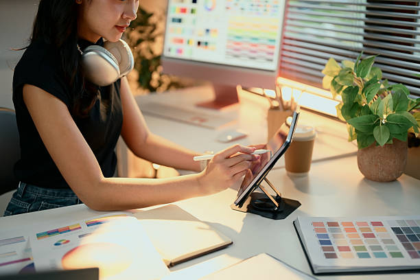 istock Cheerful graphic designer working on digital tablet in a creative studio with color palettes on screen 2220519401