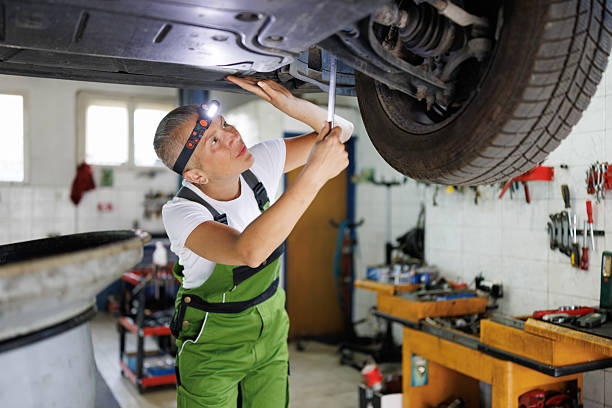 istock Female Mechanic Using Extractor to change car oil 2220522356