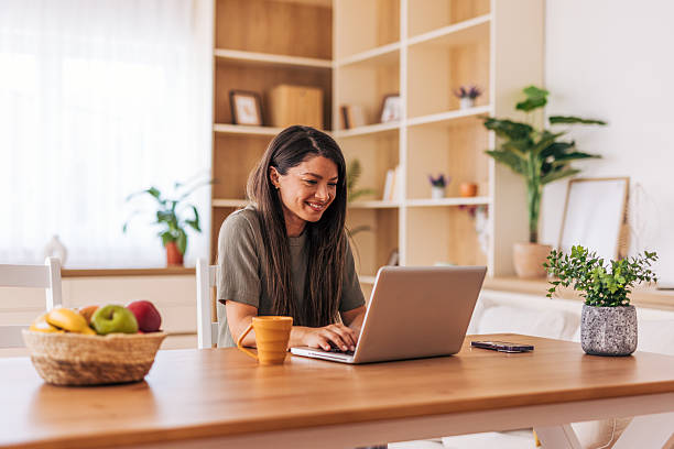 istock Young woman working from home using laptop at the table 2220527650
