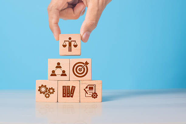 istock Wooden cube with ethics symbol held in hand. Represents corporate responsibility, integrity, and compliance in business practices. 2220527736