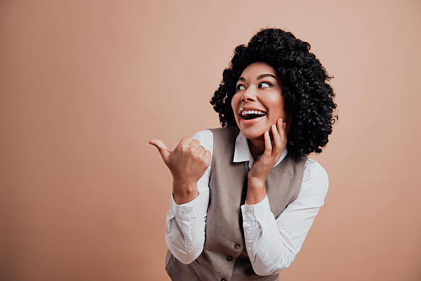 istock Confident young professional cheerfully gesturing with charming expression wearing stylish formal attire on beige backdrop 2220531907