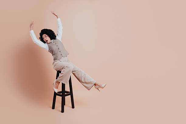istock Young professional woman gesturing dynamically on a modern beige background in stylish business attire for promotion 2220531997
