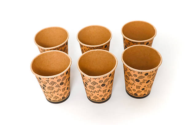 istock Six empty brown paper cups with tribal patterns stand on a white background, ready for a drink 2220533777