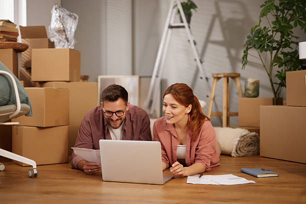 istock Couple planning new home interior design using laptop lying on floor 2220535942