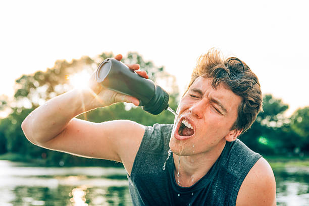 istock Young athlete refreshing himself drinking water after training outdoors 2220537669