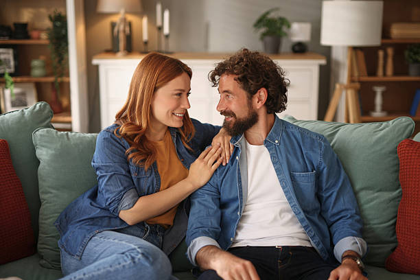 istock Happy couple relaxing and talking on sofa at home 2220537938