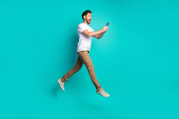 istock Young man enjoying technology interaction in a vibrant setting against a teal background 2220540390