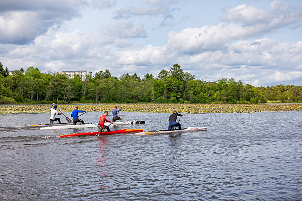 Lyngby Sø, Zealand, Denmark - June 9th 2025:  Five male canoeists training hard on an open lake on a windy summer day. Lyngby Lake is situated in a suburb north of Copenhagen