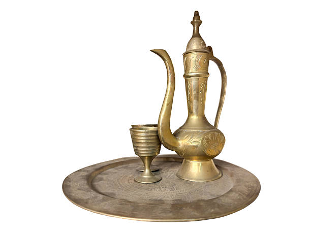 Traditional brass teapot with goblet and engraved tray isolated on white background. Ideal for cultural, antique, and Middle Eastern or South Asian heritage-themed stock content. brass utensils, antique teapot, traditional tray, vintage goblet, Middle Eastern decor, Islamic heritage, South Asian metalware, engraved brassware, old Arabian utensils, cultural artifacts, brass tea set, traditional drinkware, heritage metal crafts, antique dining set, Islamic serving tray, oriental decor, old brass set, tea serving traditions, vintage utensils isolated, Arabic tea set