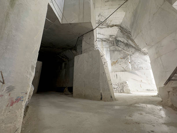 Impressive marble quarry in tunnel: geometric shapes carved in the rock, extraction technique with low landscape impact.