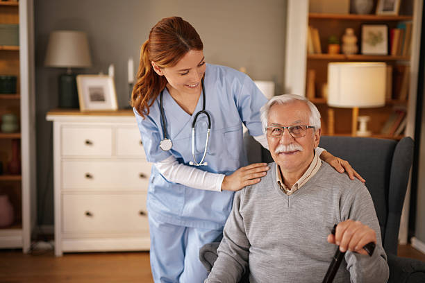 istock Nurse supporting elderly man sitting in an armchair at home 2220542923