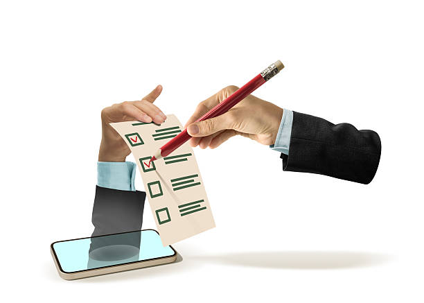 A hand with a red pencil in a business suit puts marks in a questionnaire held by another hand that has appeared from a smartphone.