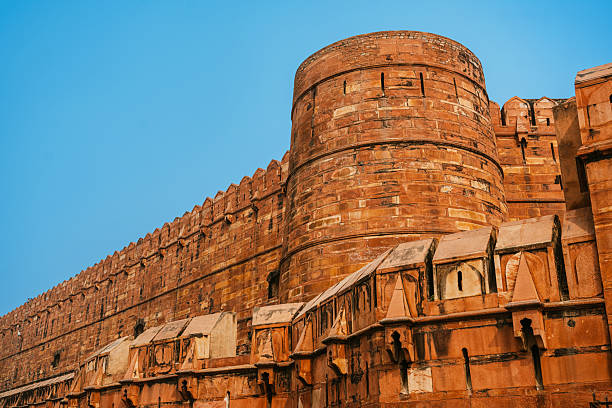 An impressive view of the Agra Fort showcasing its historic architectural design under a clear blue sky in Agra, India.