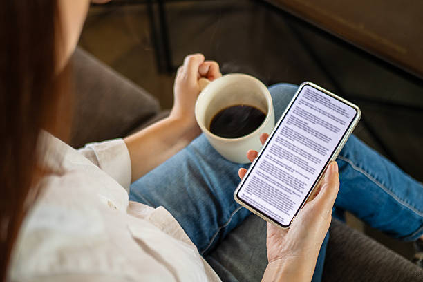 woman hand holding coffee cup and phone, reading text on mobile screen for digital press article feed in the morning. mockup media publication website in smartphone.