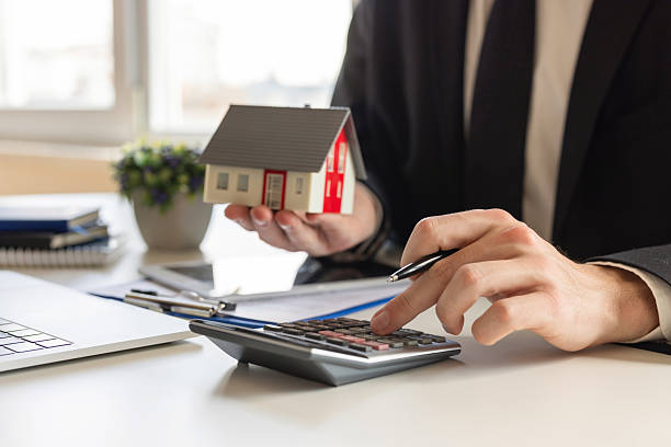 istock Man holding house model in hand 2220550820