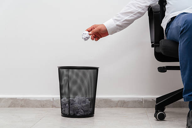 istock A man in office throwing a paper into the trash bin 2220551584