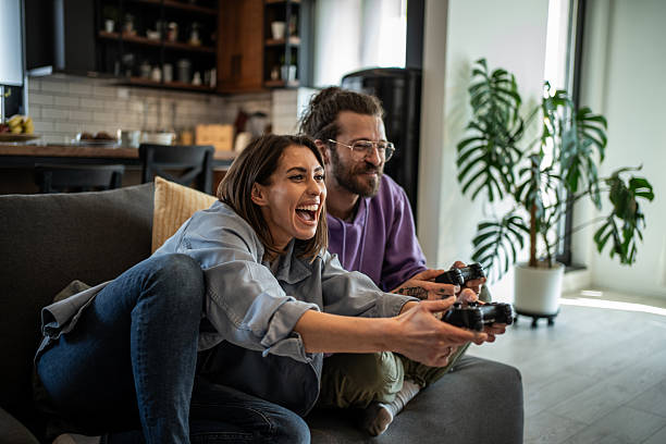 istock Enthusiastic couple playing video games at home on the couch 2220552210
