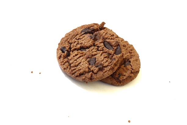 Two chocolate chip cookies on a white surface offer a tempting treat.