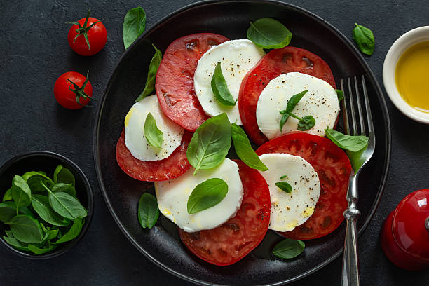 istock Caprese salad with fresh tomatoes, mozarella cheese, basil and olive oil 2220559780