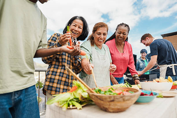 istock Multigenerational people doing barbecue at home's rooftop - Multiracial friends having fun eating and cooking together during weekend day - Summer and food concept - Main focus on african woman face 2220562306
