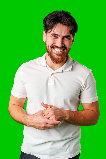 istock A smiling young man with a beard poses against a bright green background 2220563427