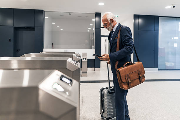 istock Businessman Navigating Airport Security Checkpoint With Luggage and Documents 2220563624