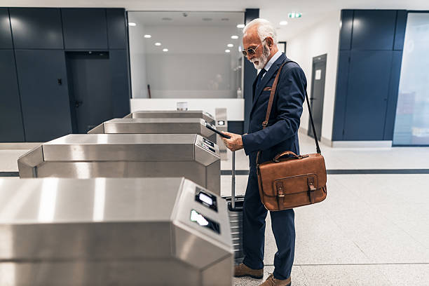 Elderly Businessman Using Ticket Machine at Modern Transportation Hub
