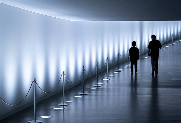 Germany, Berlin, Central Berlin, May 26, 2024 - Rear view of two people walking through an illuminated pedestrian tunnel