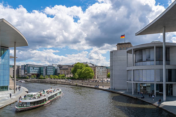 Germany, Berlin, May 29, 2025 - Passenger ship on the Spree in Berlin's government district with Paul-Löbe-Building and Reichstag against cloudy sky