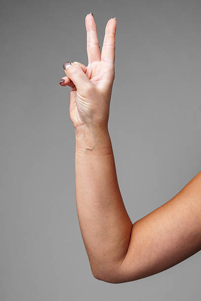 istock A hand gestures the peace sign against a neutral gray background 2220564412