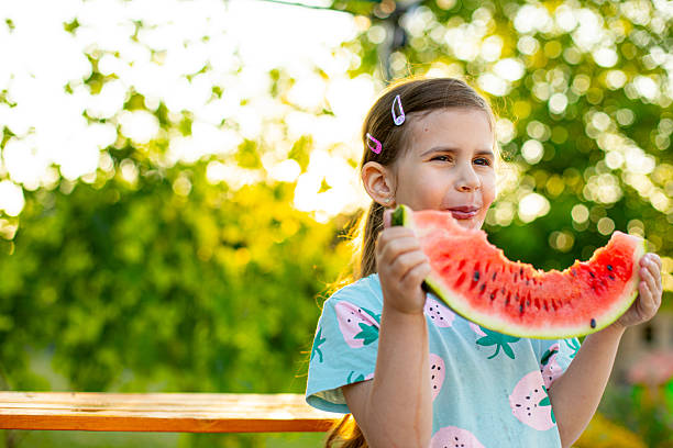 istock Summer Fun: Child Eating Fresh Watermelon in the Backyard 2220565511