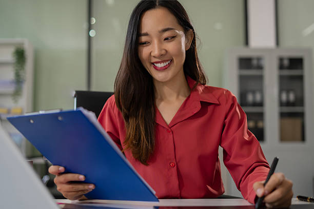 istock Businesswomen hand working with paperwork and laptop computer with documents on office desk in modern office. 2220565618