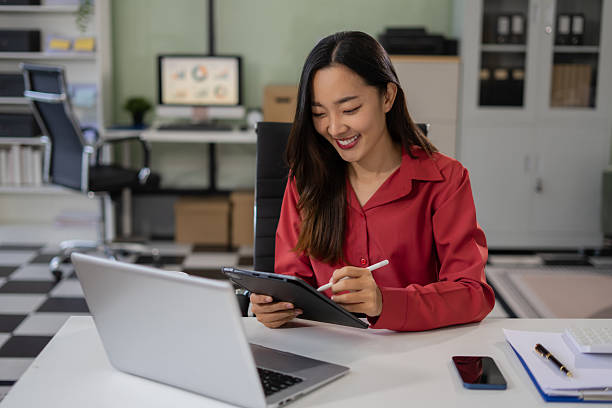 istock Businesswoman working with laptop, smartphone, and tablet. modern digital workspace concept. 2220565643