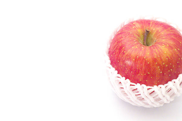 A red apple wrapped with a cushioning net with white background